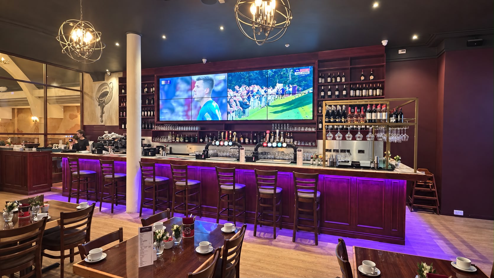 The Tavern Co. Social bar with bar stools and a wall of big screens showing sport
