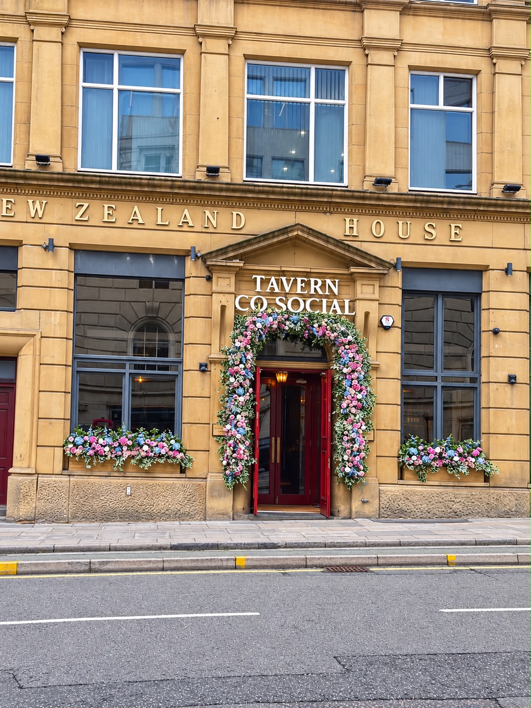 The Tavern Co. Social entrance on Water Street, framed by a floral arch